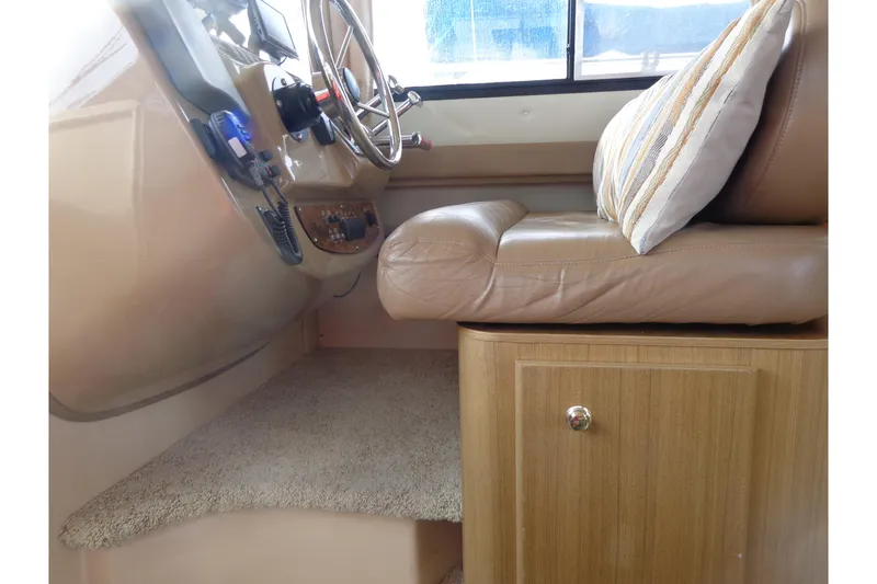 Slide: The Image of 2001 Bayliner 3488 Command Bridge Motoryacht helm with leather seating and striped cushion. - 40