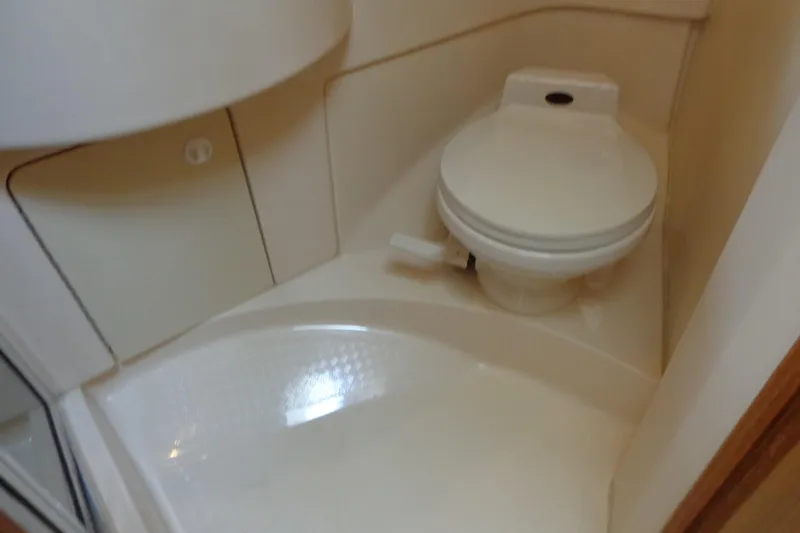 Slide: The Image of Compact bathroom in 2001 Bayliner 3488 Command Bridge Motoryacht, featuring a marine toilet. - 49