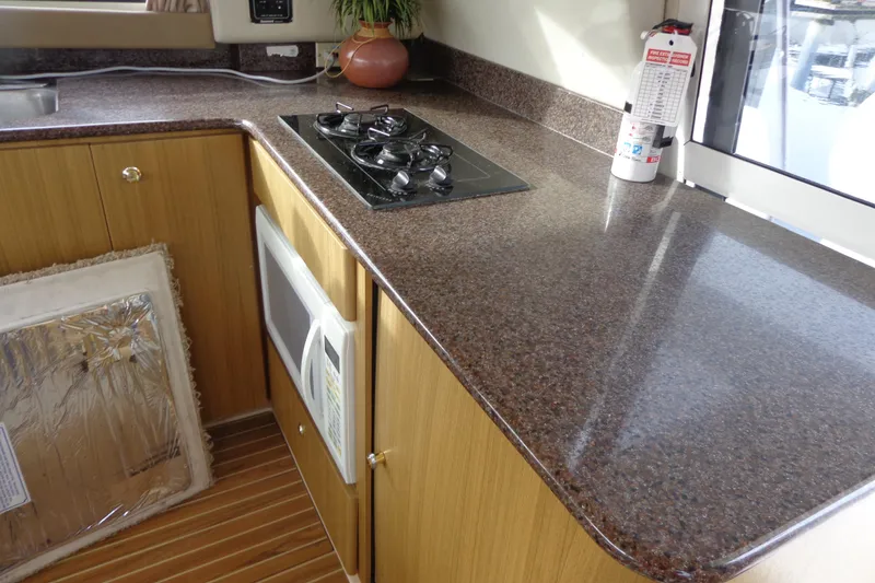 Slide: The Image of 2001 Bayliner 3488 Command Bridge Motoryacht kitchen with stove, microwave, and fire extinguisher. - 59