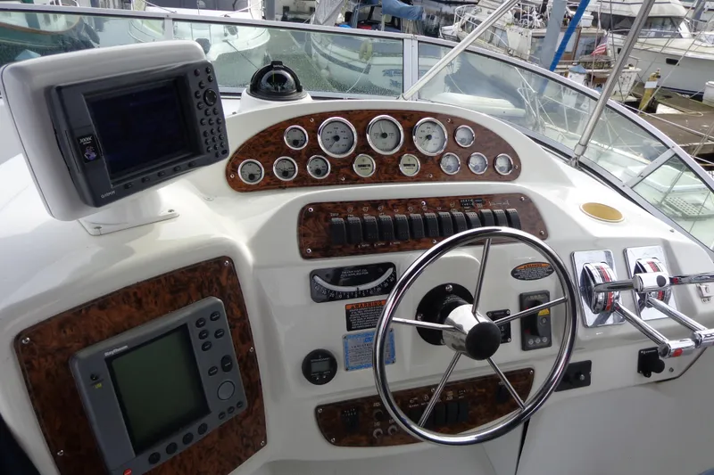 Slide: The Image of 2001 Bayliner 3488 Command Bridge Motoryacht helm with navigation instruments and steering wheel. - 60