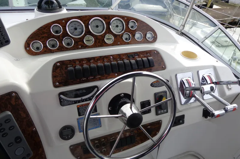 Slide: The Image of 2001 Bayliner 3488 Command Bridge Motoryacht helm with gauges, steering wheel, and controls. - 62