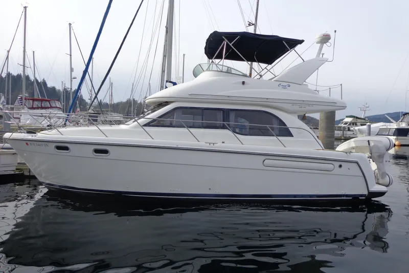 Slide: The Image of 2001 Bayliner 3488 Command Bridge Motoryacht with attached dinghy and green rope on deck. - 9