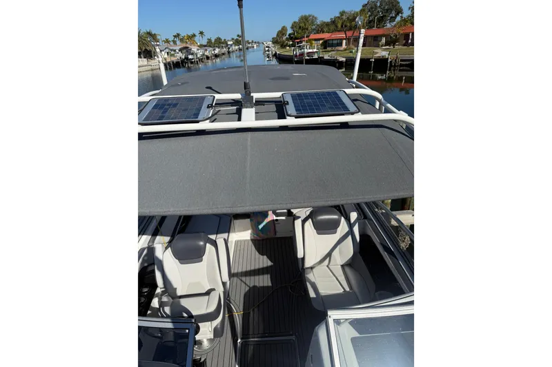 Slide: The Image of 2017 Yamaha Boats 242 Limited S E-Series with solar panels, docked in a scenic canal. - 28