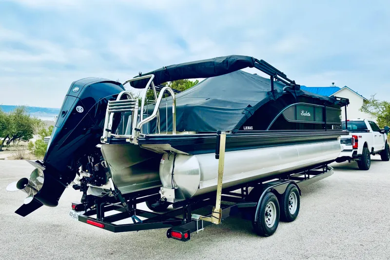 Slide: The Image of 2019 Barletta L23UC pontoon boat on trailer, parked outdoors. - 11