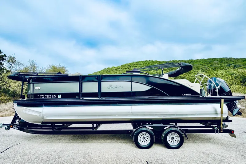 Slide: The Image of 2019 Barletta L23UC pontoon boat on trailer, parked outdoors. - 13