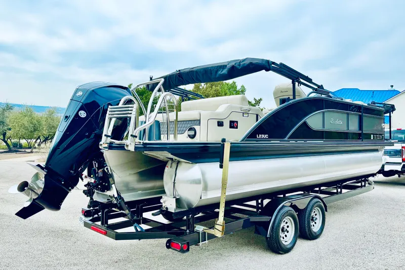 Slide: The Image of 2019 Barletta L23UC pontoon boat on trailer, featuring sleek design and powerful outboard motor. - 14