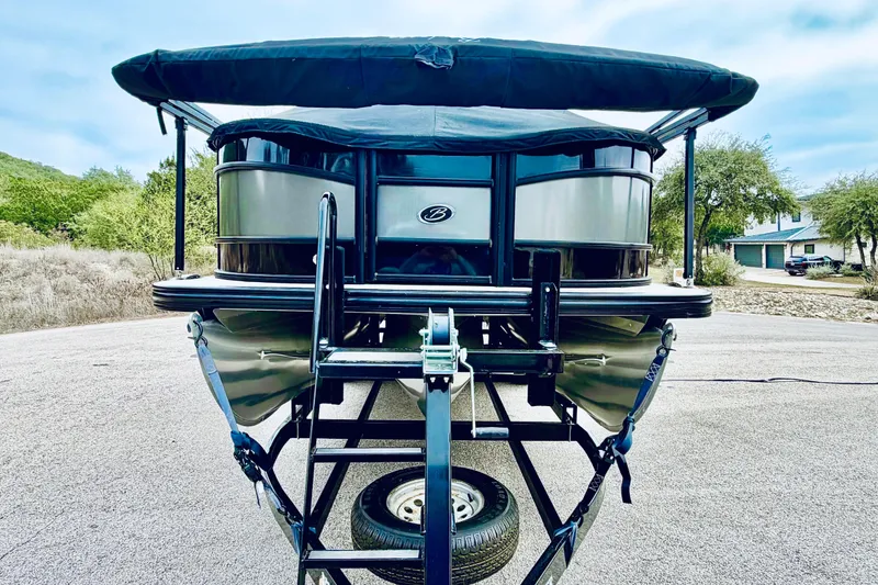 Slide: The Image of 2019 Barletta L23UC pontoon boat on trailer, parked outdoors. - 15