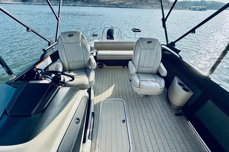 Slide: The Image of 2019 Barletta L23UC boat interior with plush seating on a calm lake. - 18