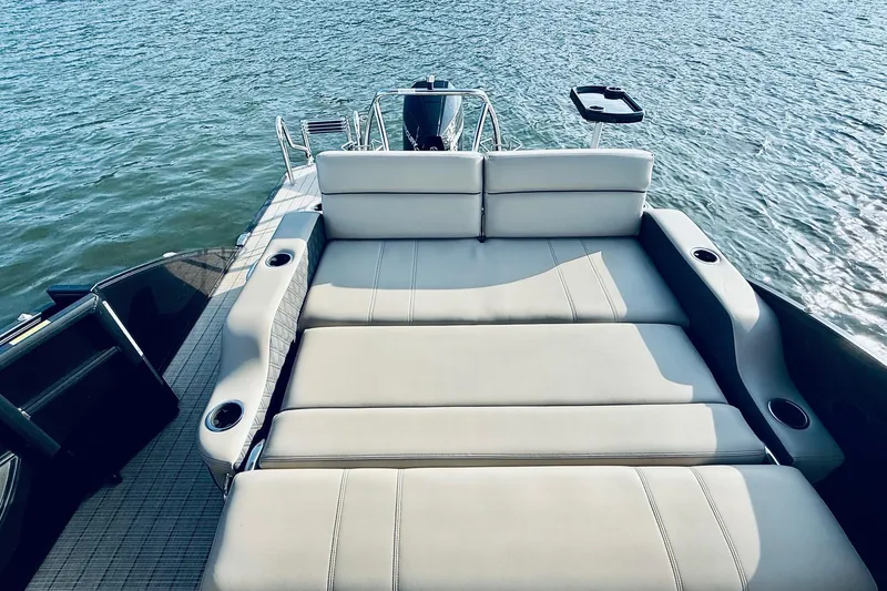 Slide: The Image of 2019 Barletta L23UC pontoon boat with luxurious seating on a serene water backdrop. - 19