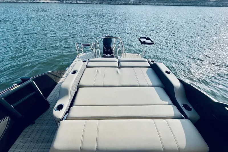 Slide: The Image of 2019 Barletta L23UC pontoon boat with spacious sunbathing deck on a serene lake. - 20