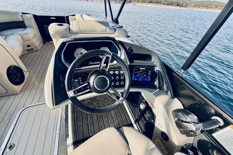 Slide: The Image of 2019 Barletta L23UC boat cockpit with steering wheel and control panel on water. - 22