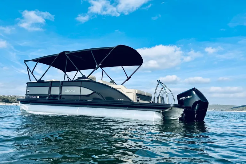 Slide: The Image of 2019 Barletta L23UC pontoon boat on water under blue sky. - 4