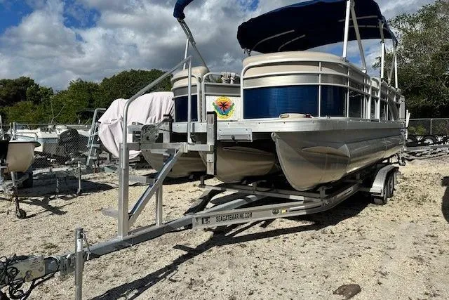 The Image of 2015 Bennington 21gs pontoon boat on trailer with blue canopy and Yamaha motor. - 0