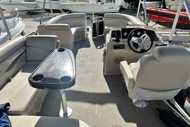 Slide: The Image of 2015 Bennington 21gs pontoon boat interior with cushioned seating and table. - 13
