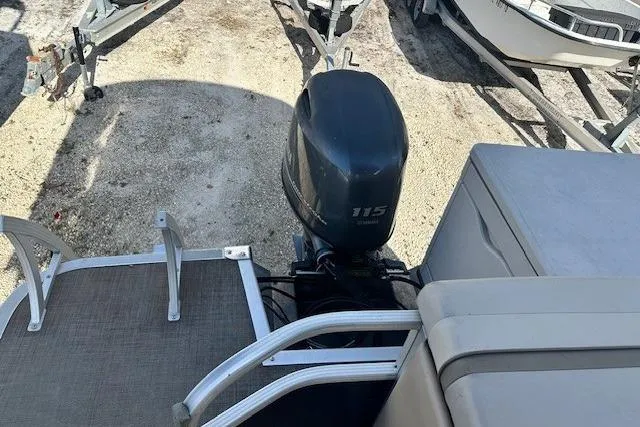 Slide: The Image of 2015 Bennington 21gs boat with 115 horsepower outboard motor, docked on gravel. - 17