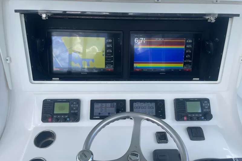 Slide: The Image of 2016 Contender 39 ST boat dashboard with Garmin navigation displays and controls. - 11