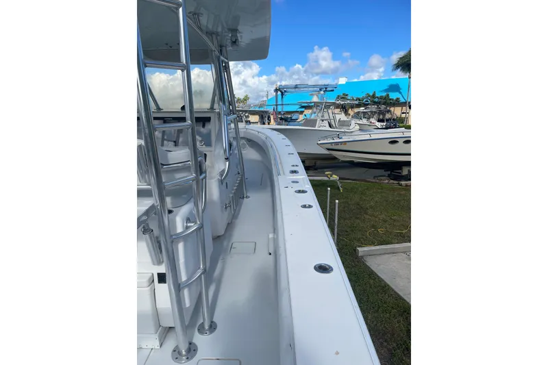 Slide: The Image of 2016 Contender 39 ST boat docked, showcasing sleek design and spacious deck. - 19