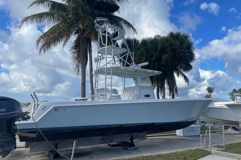 Slide: The Image of 2016 Contender 39 ST boat on display with palm trees and cloudy sky background. - 2