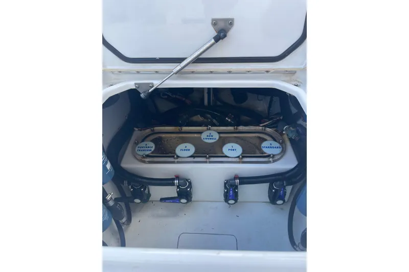 Slide: The Image of 2016 Contender 39 ST boat compartment with labeled valves and hoses. - 20
