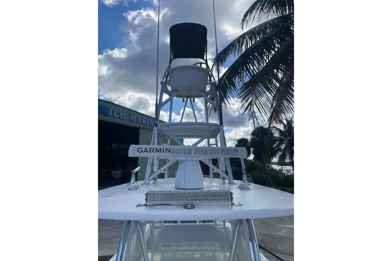 Slide: The Image of 2016 Contender 39 ST boat with Garmin radar, palm trees, and cloudy sky background. - 5