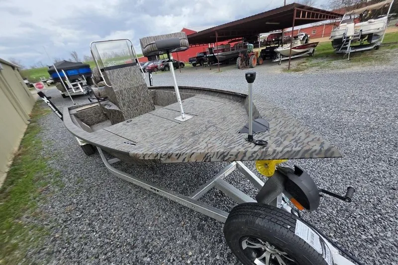 Slide: The Image of 2026 Xpress H190B Bay boat on trailer, camo design, parked on gravel. - 10
