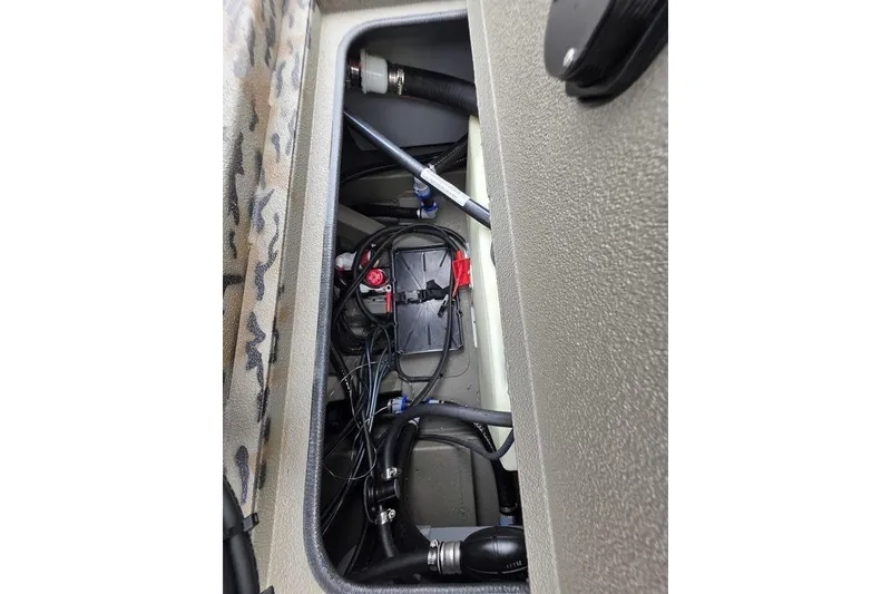 Slide: The Image of 2026 Xpress H190B Bay boat battery compartment with wiring and connections. - 16