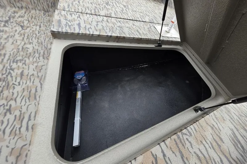 Slide: The Image of Open storage compartment in 2026 Xpress H190B Bay boat with camo interior. - 19