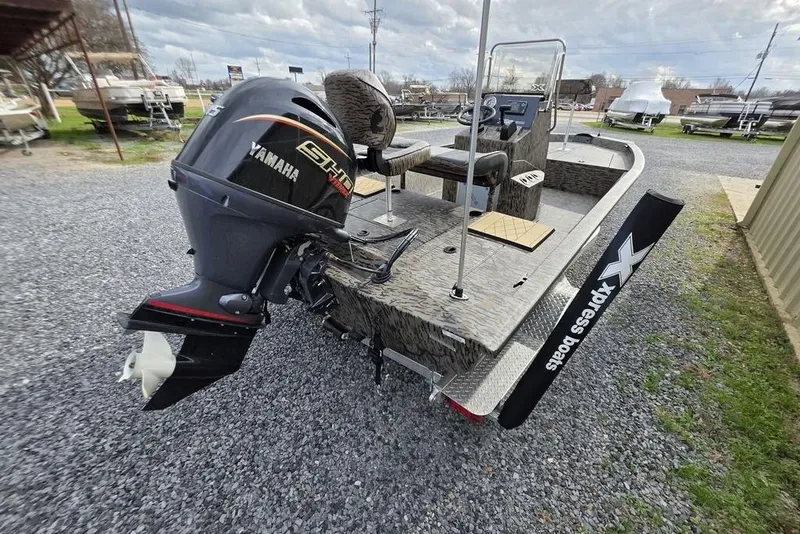 Slide: The Image of 2026 Xpress H190B Bay boat with Yamaha outboard motor, parked on gravel. - 5
