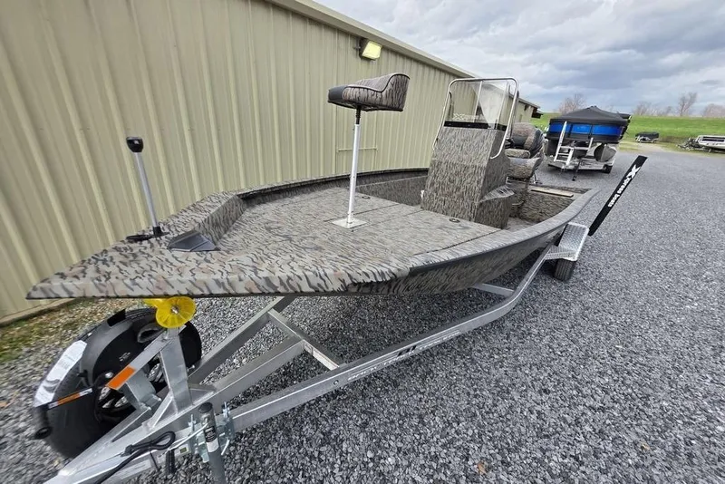 Slide: The Image of 2026 Xpress H190B Bay boat on trailer, camo design, parked on gravel. - 6