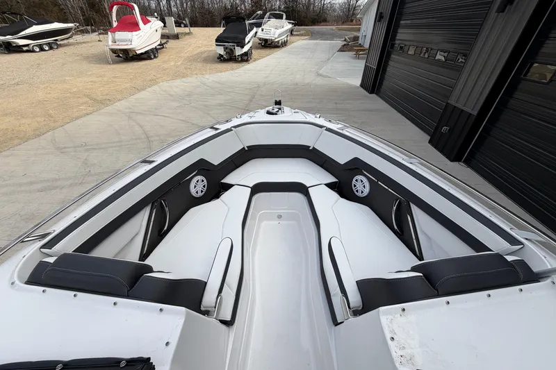 Slide: The Image of 2025 Monterey 278SS Super Sport boat interior with white and black seating, cup holders, and speaker. - 11