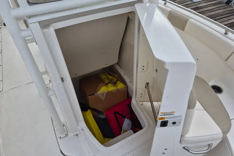 Slide: The Image of Open storage compartment on 2017 Robalo R222 Center Console boat with various items inside. - 12