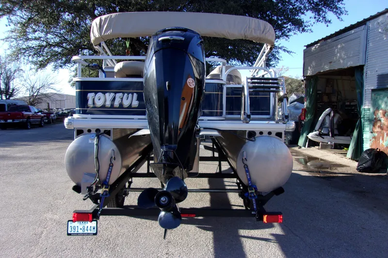 Slide: The Image of 2023 Sun Tracker Bass Buggy 18 DLX pontoon boat with outboard motor, rear view. - 3