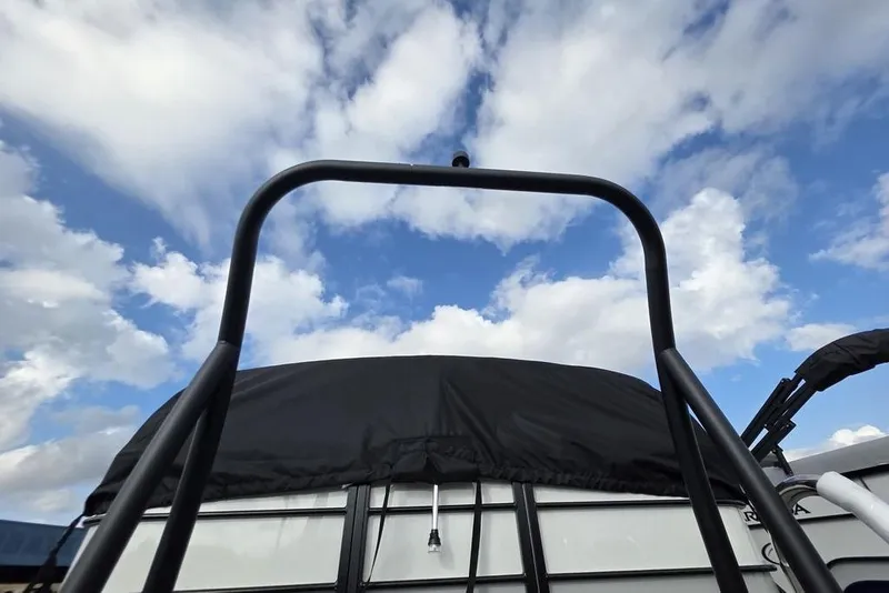 Slide: The Image of 2026 Veranda Vista Sport 22RC Tri-Toon boat with black canopy against a cloudy sky. - 6