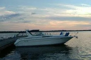 The Image of 1990 Sea Ray Sundancer 350 yacht on calm water at sunset. - 0