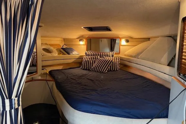 Slide: The Image of Interior cabin of 1990 Sea Ray Sundancer 350 with cozy bedding and striped pillows. - 15