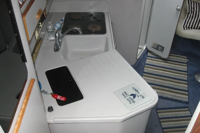 Slide: The Image of Interior cabin of a 1990 Sea Ray Sundancer 350 with striped curtains and cozy seating. - 18