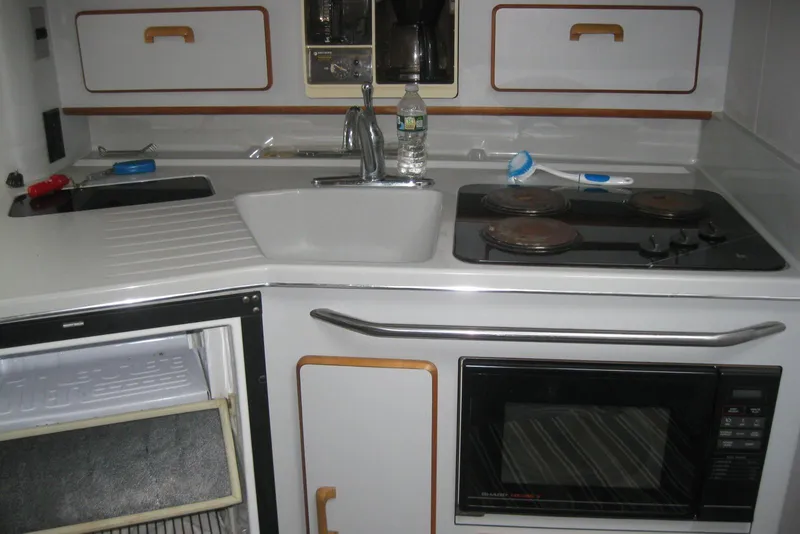 Slide: The Image of Interior of 1990 Sea Ray Sundancer 350, featuring cozy seating and a wooden table. - 21