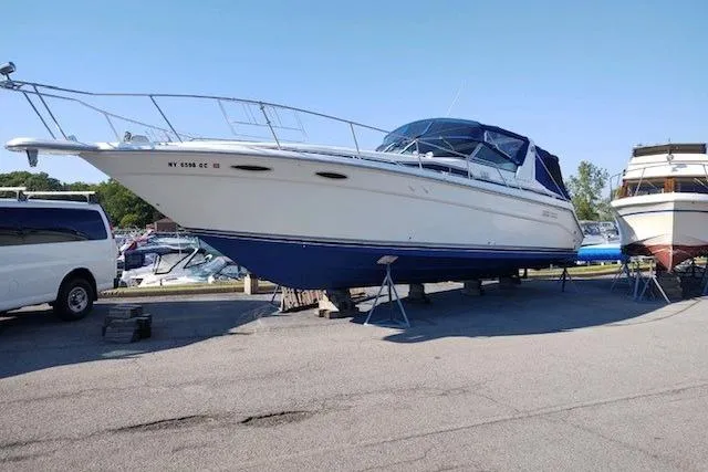 Slide: The Image of 1990 Sea Ray Sundancer 350 boat on stands in a marina parking lot. - 8