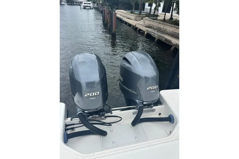 Slide: The Image of 2022 Robalo R272 Center Console with twin Yamaha 200 engines docked by a canal. - 3