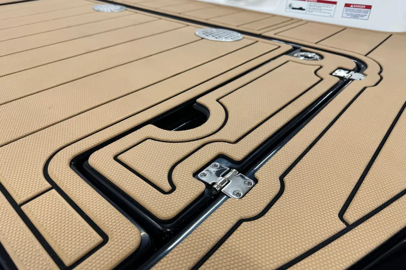 Slide: The Image of 2026 Chaparral SSX 4 boat deck with textured tan surface and metal hinges. - 12