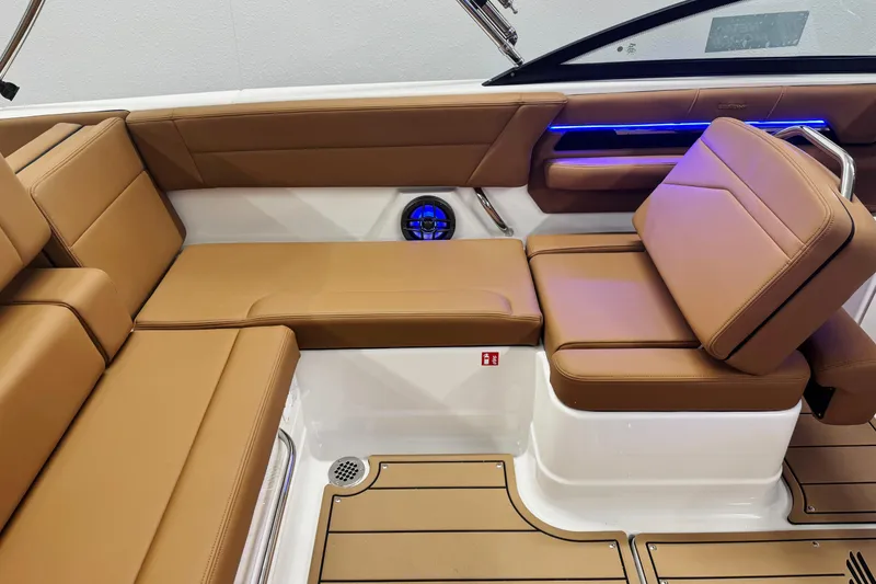 Slide: The Image of 2026 Chaparral SSX 4 boat interior with tan leather seating and blue LED lighting. - 21