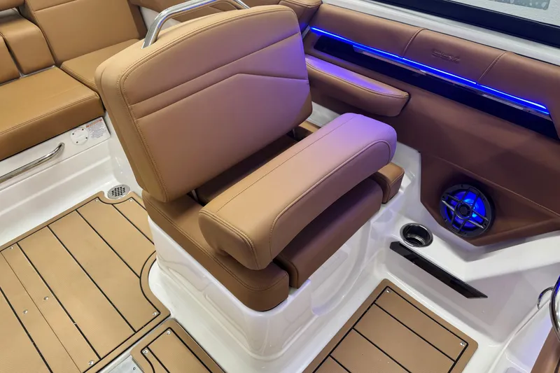 Slide: The Image of 2026 Chaparral SSX 4 boat interior with tan seating, blue LED lighting, and speaker system. - 23