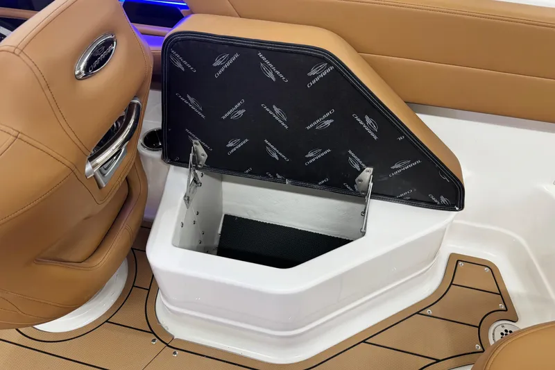 Slide: The Image of 2026 Chaparral SSX 4 boat interior storage compartment with tan seating and branded cover. - 28