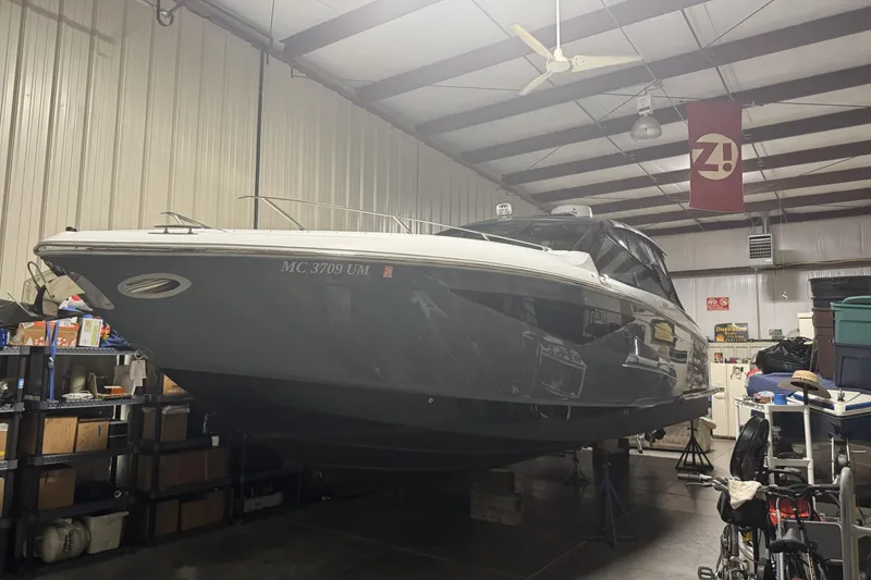 Slide: The Image of 2020 Cobalt A36 boat in a garage, surrounded by storage shelves and equipment. - 2