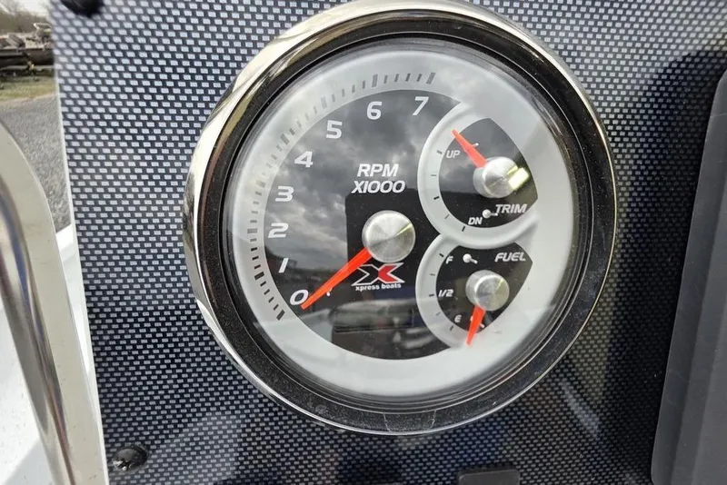 Slide: The Image of 2026 Xpress H20B Bay boat dashboard with RPM, trim, and fuel gauges. - 33