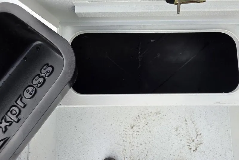 Slide: The Image of 2026 Xpress H20B Bay boat storage compartment with open lid, showing interior space. - 39