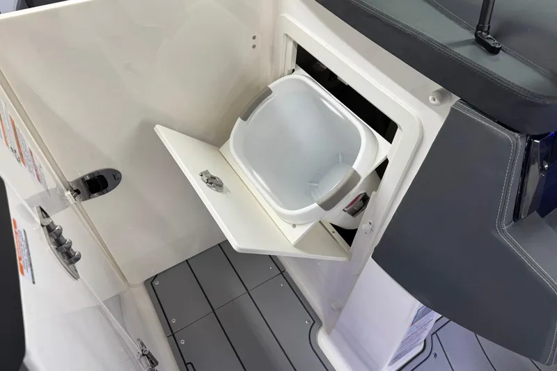Slide: The Image of 2026 Chaparral SSX 6 boat interior with built-in storage compartment and bucket. - 34
