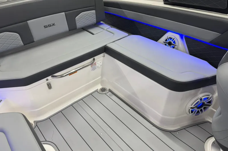 Slide: The Image of 2026 Chaparral SSX 6 boat interior with gray seating, blue LED lighting, and speaker system. - 26