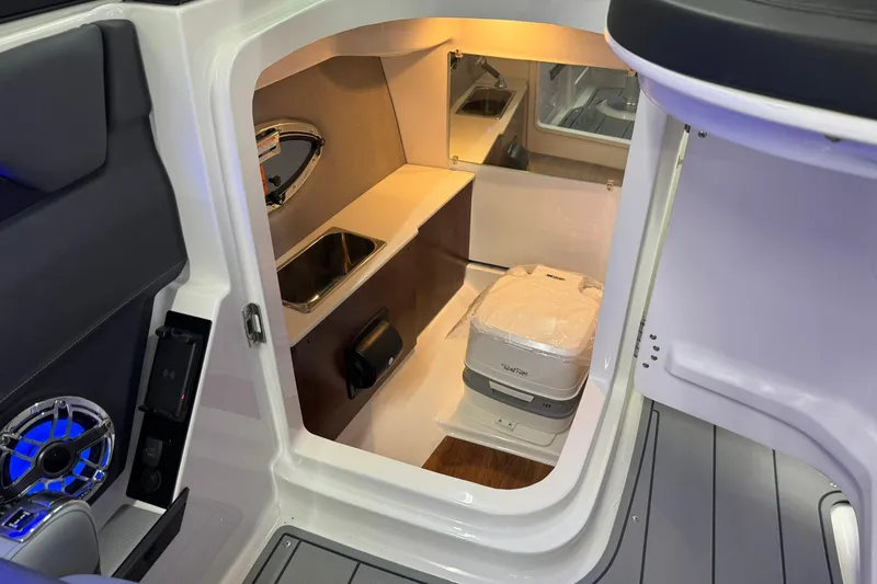 Slide: The Image of Interior of 2026 Chaparral SSX 6 boat featuring compact cabin with sink and toilet. - 24