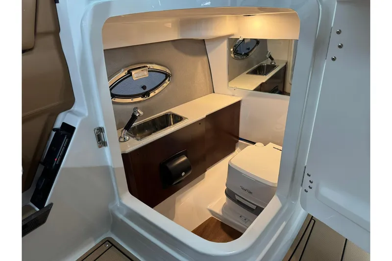 Slide: The Image of 2026 Chaparral SSX 6 boat interior with sink, mirror, and compact toilet. - 33